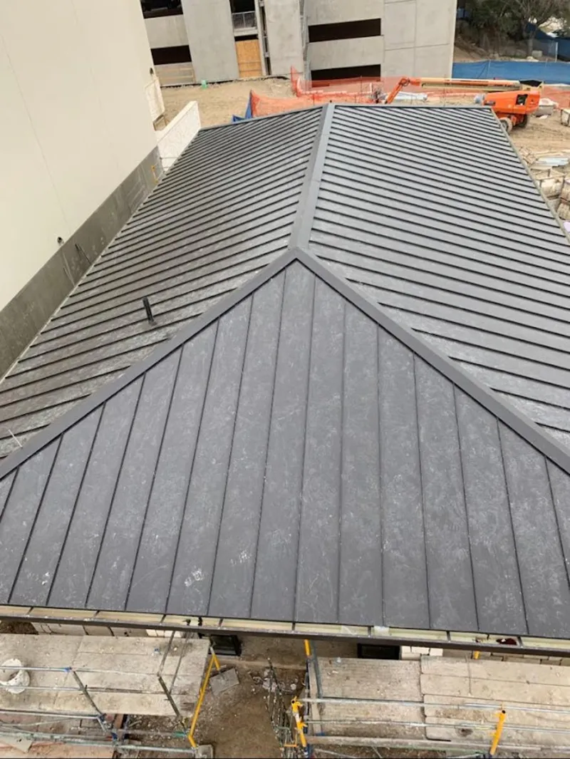 Commercial metal roof construction with crane equipment in Columbia City